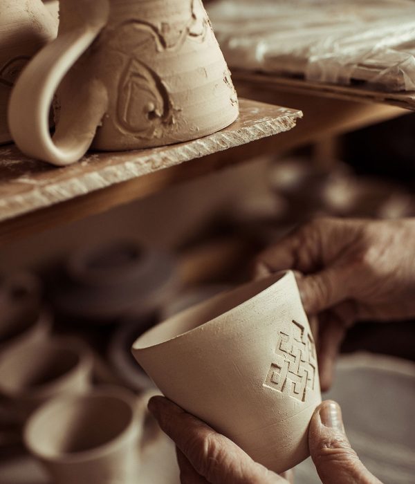close-up-of-male-hand-of-potter-examining-clay-cup-resize