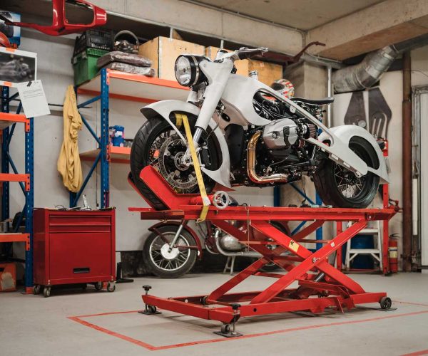 Fixing Custom motorcycle standing in repair shop. Instruments and equipment. Hobbies and unique Jobs