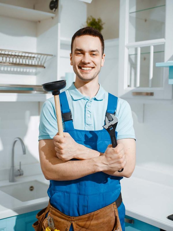cheerful-male-plumber-holds-wrench-and-plunger-resize